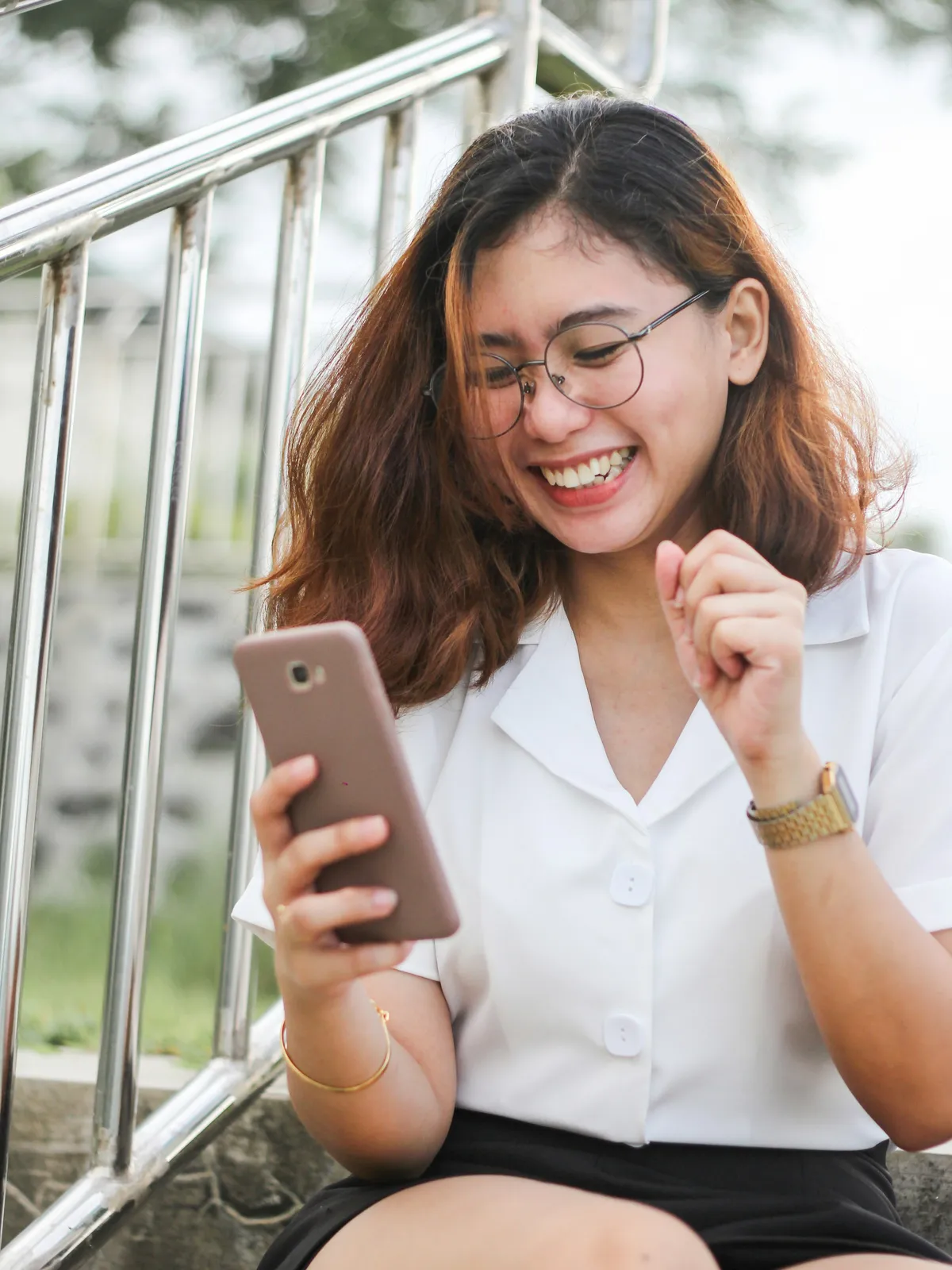Mulher sorrindo enquanto usa o celular